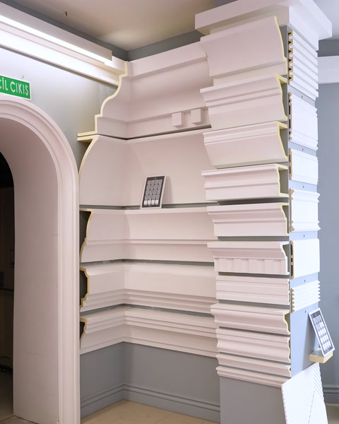 Layered cornice profiles displayed at showroom entrance archway corner