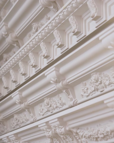 Layered decorative cornice moldings with dentil and floral trim details