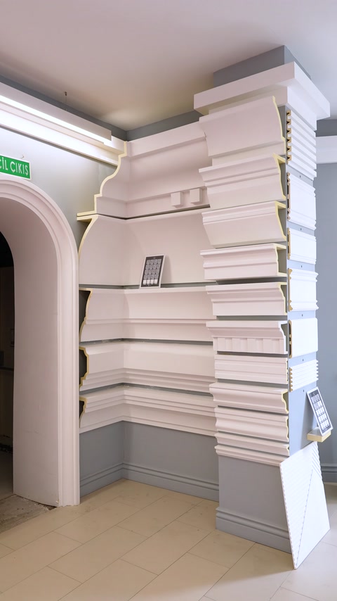 Layered cornice profiles displayed at showroom entrance archway corner