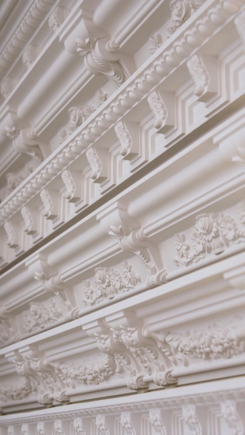 Layered decorative cornice moldings with dentil and floral trim details