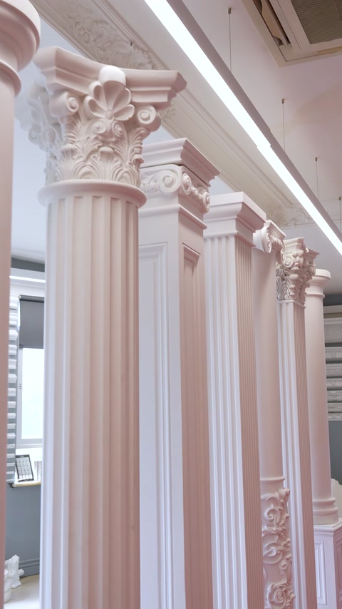 Pink-toned Corinthian columns arranged in a row inside showroom
