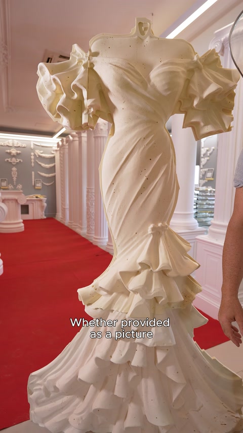 Una vista ravvicinata frontale della forma drappeggiata del rilievo a forma di abito da sposa senza testa.