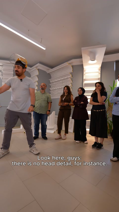Yetkili, dekoratif rölyefin önünde ürün detaylarını açıklıyor.
