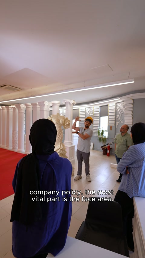 Showroom ziyaretçileri, merkezi gelinlik kabartması çevresinde sunumu takip ediyor.