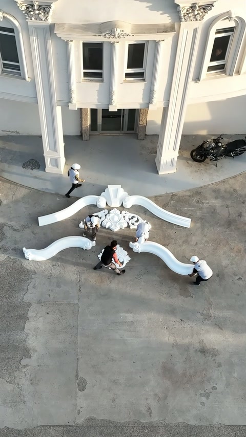 I membri dell'equipaggio regolano l'ornamento centrale tra due sezioni curve che si allargano.