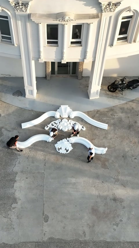 Gli operai dispongono le sezioni di cornice curva inferiore in un profilo simmetrico.