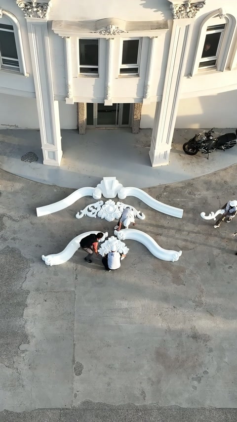 Gli operai allineano l'estremità destra della curva decorativa inferiore.