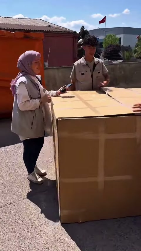 Nel giardino dell'officina, gli addetti attendono intorno a una cassa di spedizione chiusa