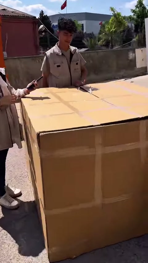 Gli addetti si preparano a sciogliere le reggette sull'imballaggio di cartone