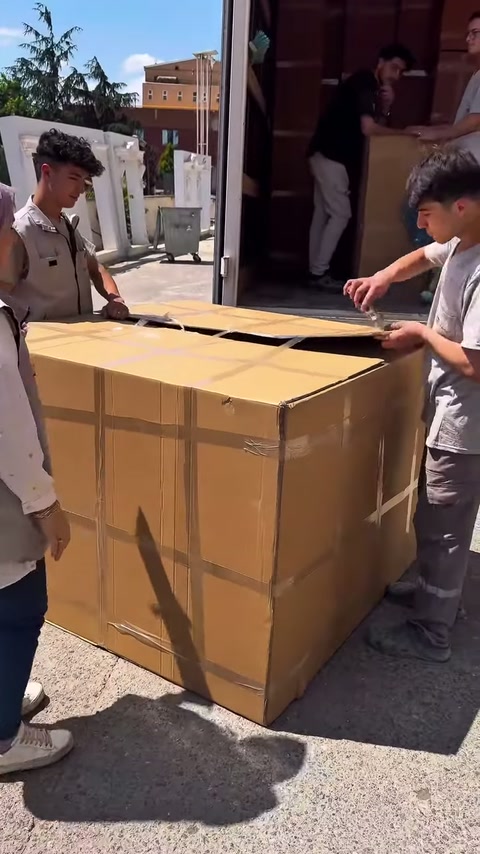 La squadra si posiziona per aprire il coperchio nastrato della scatola larga