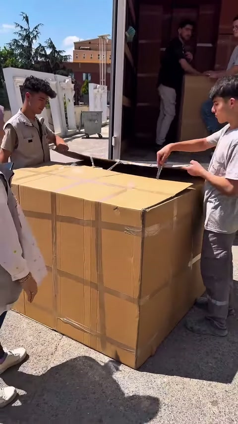 Gli addetti separano le fasce dell'imballaggio all'aperto, sotto il sole