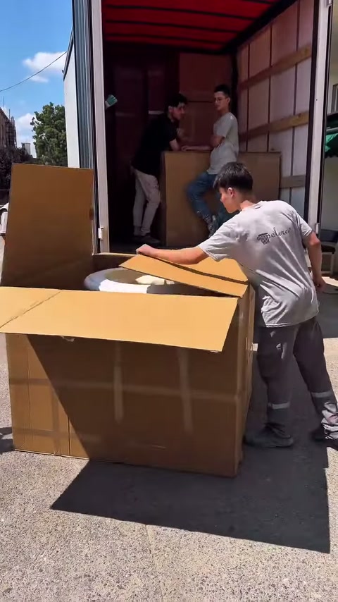 Un addetto abbassa il coperchio di cartone anteriore e raggiunge l'interno