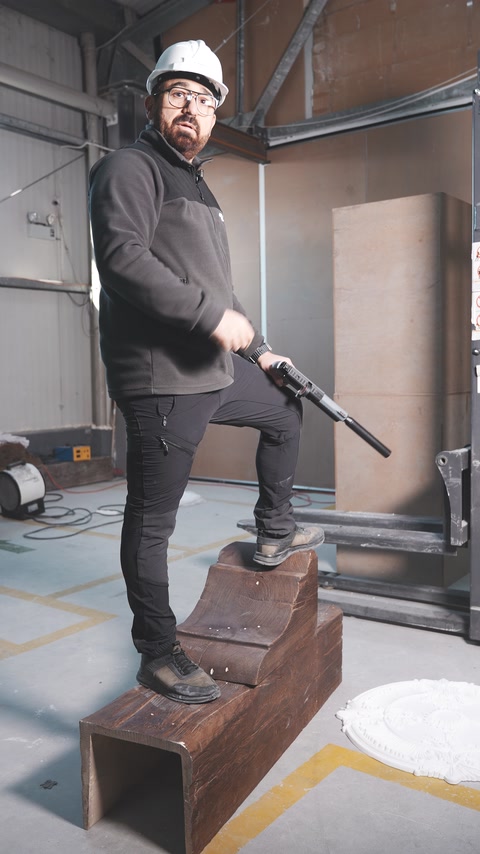 Demonstrator stands on a wood-look polyurethane beam during a pressure test.