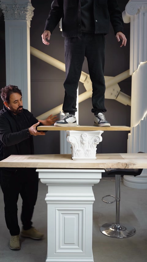Demonstrator stands on a plank supported by ornate polyurethane capitals.