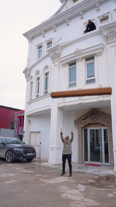 Man tosses a decorative element outside an ornamented building entrance.