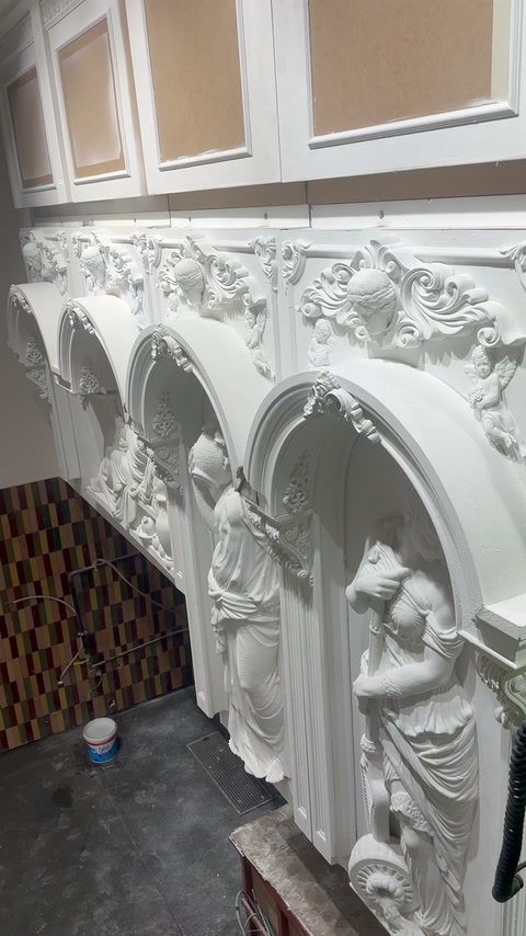 Tre nicchie scultoree ad arco ricevono modanature ornate durante l’installazione interna