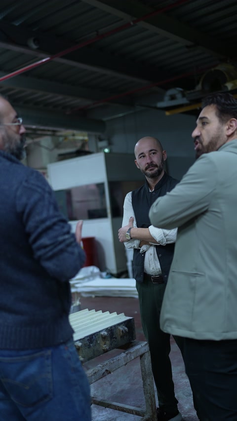 Gli artisti esaminano insieme i componenti decorativi al banco di lavoro del laboratorio