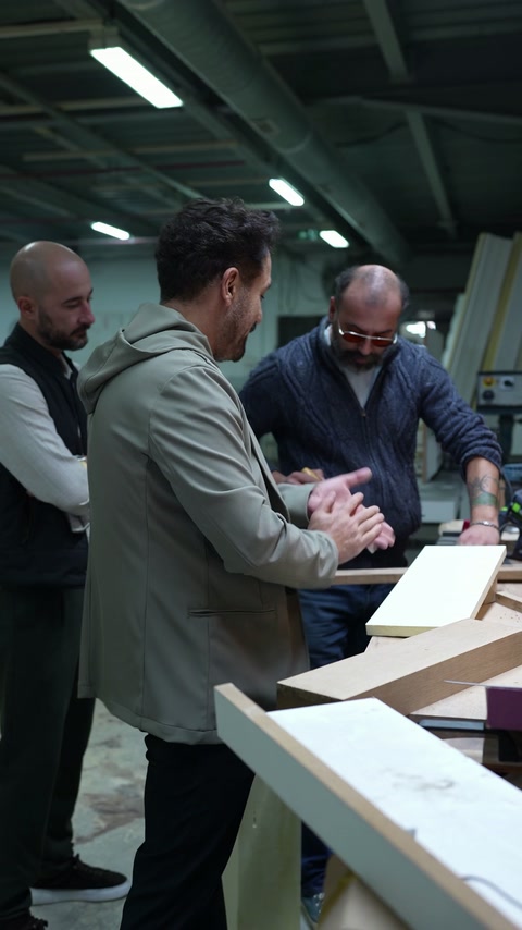 Gli scultori confrontano profili decorativi e componenti attorno al tavolo da lavoro