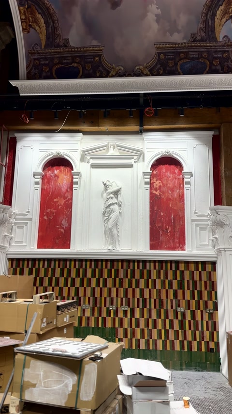 Una parete parzialmente completata presenta due archi e una scultura centrale