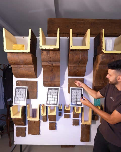Addetto che illustra diversi campioni di motivi effetto legno sul pannello espositivo dello showroom