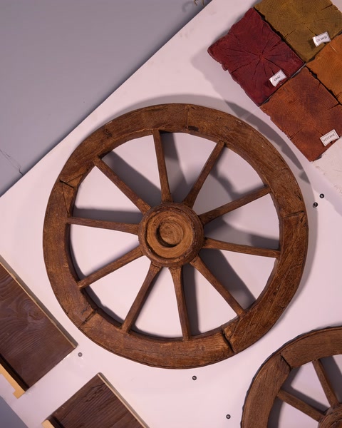 Campioni effetto legno colorati accanto a un elemento decorativo a forma di ruota