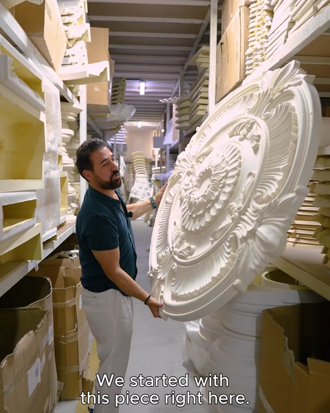 A round ceiling medallion is examined and presented by hand