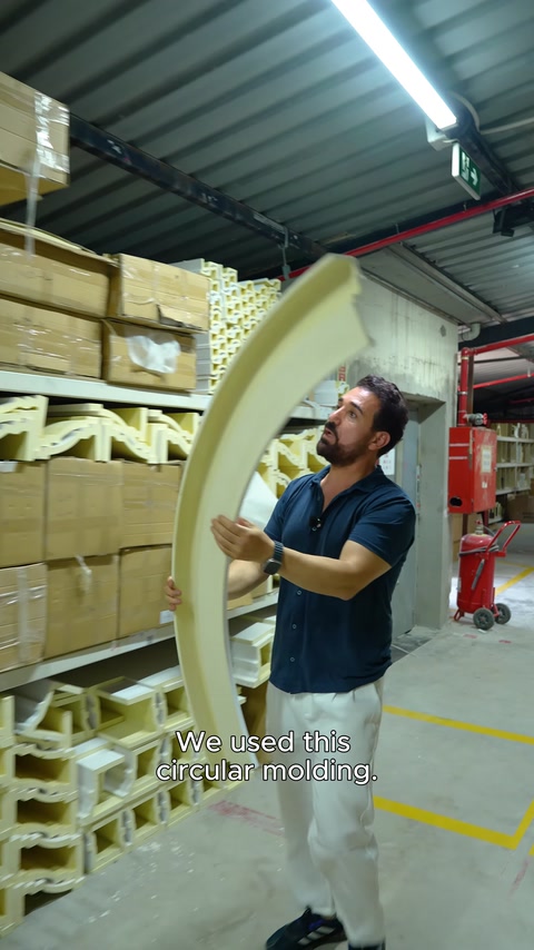 Un profilo di modanatura circolare viene tenuto in mano nel magazzino per mostrarne i dettagli.