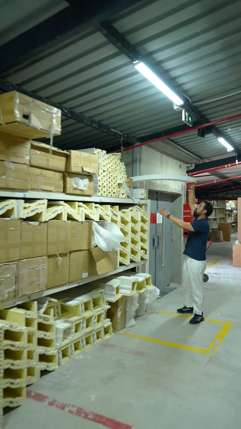 Pezzo selezionato trasportato nel vasto magazzino tra gli scaffali con profili.