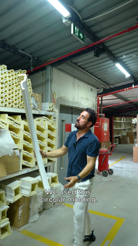 Profilo in poliuretano curvo tenuto verticale in magazzino per ispezionare la forma.