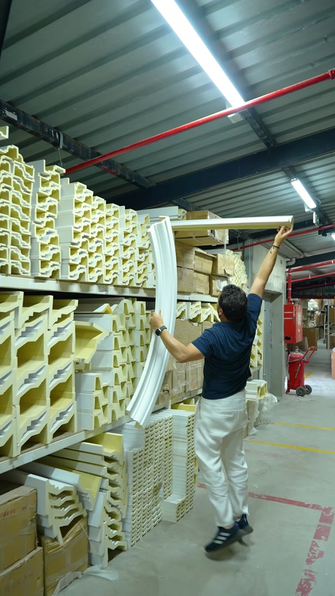 Profilo sovrapporta lungo e curvo calato con cautela dallo scaffale alto.