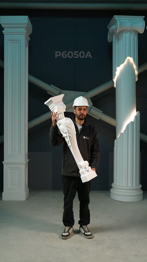 This video shows a craftsman highlighting a white pilaster ornament beside finished columns.