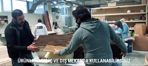 Two people working on the beam product in the workshop