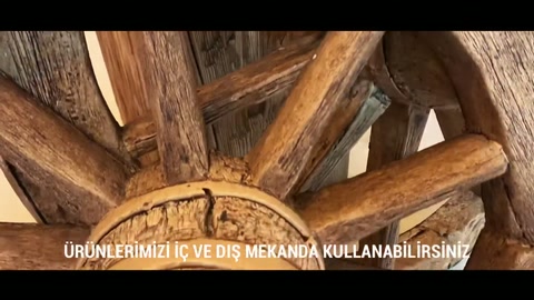 The arms of a decorative wagon wheel are surrounded by rustic beams.