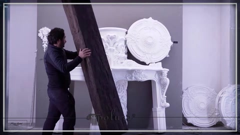 Elemento decorativo di colore scuro lungo visibile tra ornamenti bianchi.