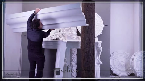 Modanatura orizzontale bianca lunga posizionata sopra i capitelli decorativi.