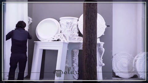 Dairesel dekor parçası, büyük oyma motifli panelin önünde inceleniyor