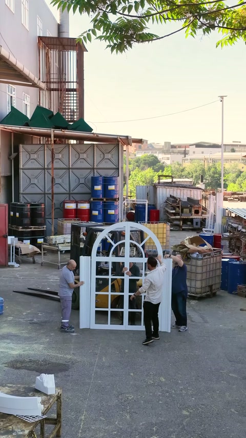 I lavoratori dispongono alte sezioni di stipite ad arco intorno alla cornice della finestra in piedi