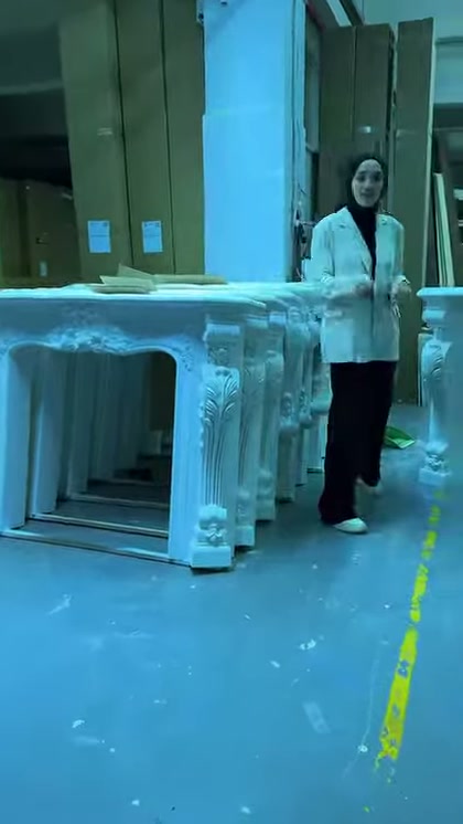 Cornici camini in rilievo già assemblate sono esposte accanto al supervisore in officina