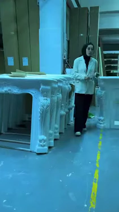 Il supervisore si trova davanti a diversi modelli di camini lavorati nell'area di produzione