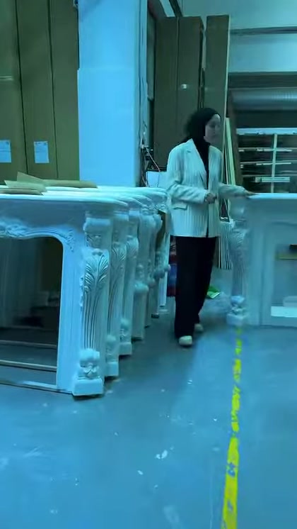Corpi camini decorativi bianchi sono allineati in fila sul pavimento dell'officina