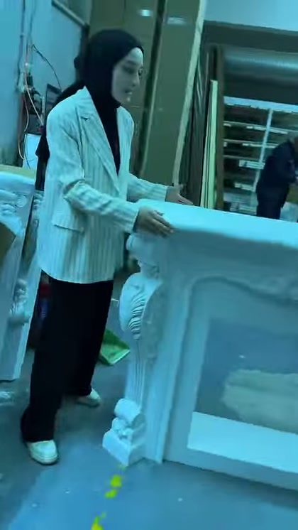 Il supervisore mostra da vicino l'ampio piano superiore della cornice camino bianca