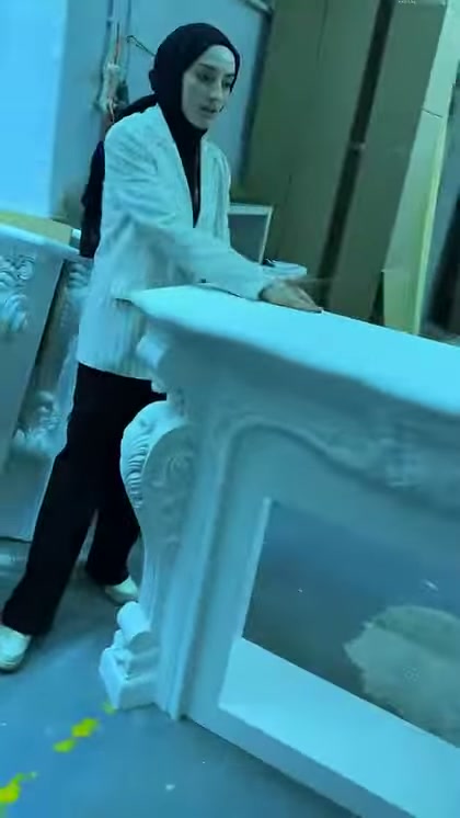 Il piano superiore spesso della cornice camino bianca è visibile da vicino in officina
