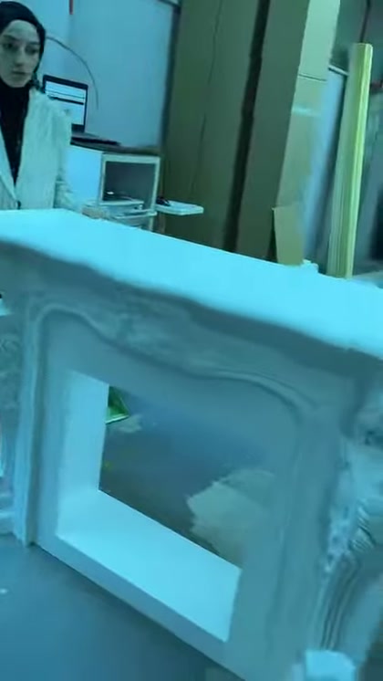 Nel primo piano sono mostrati la cornice dritta del camino e la decorazione dello spigolo
