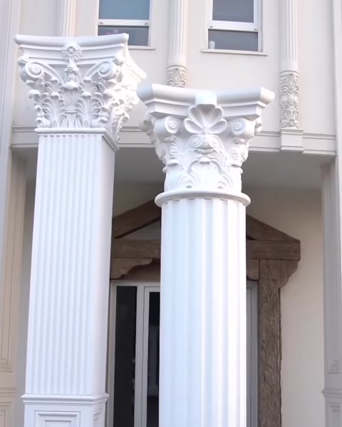 Two completed fluted columns stand along facade.