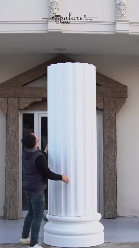 Man wraps fluted panel around column shaft on building.