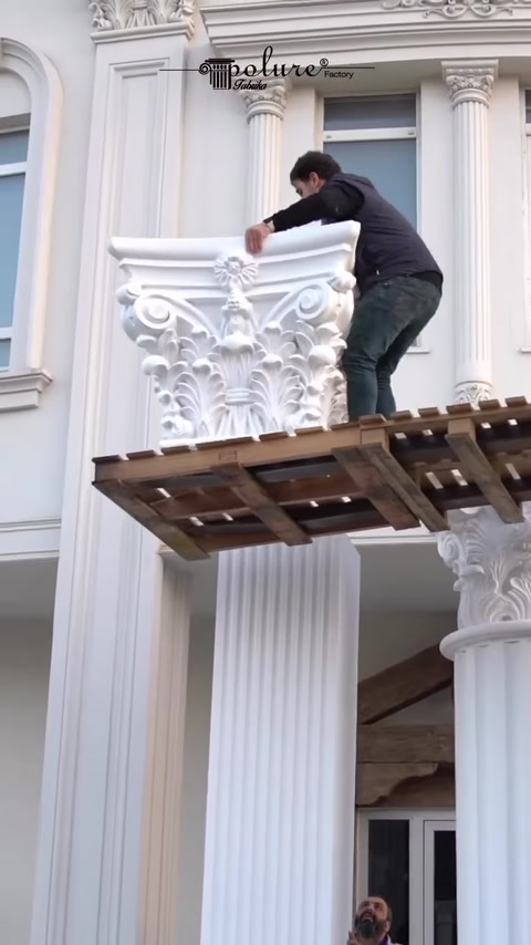 Installer attaches decorative capital to top of column.