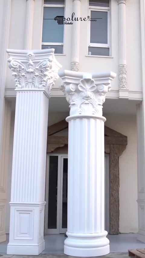 Two completed fluted columns stand along facade.