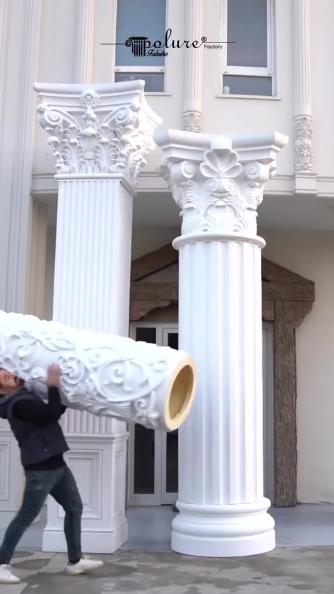 Worker carries hollow polyurethane capital piece on platform.