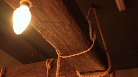 Trave rustica effetto legno con dettaglio di lampadina a sospensione
