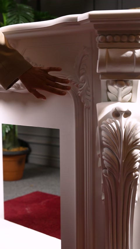 Il gesto della mano mostra il profilo dell'angolo e i motivi botanici del camino.